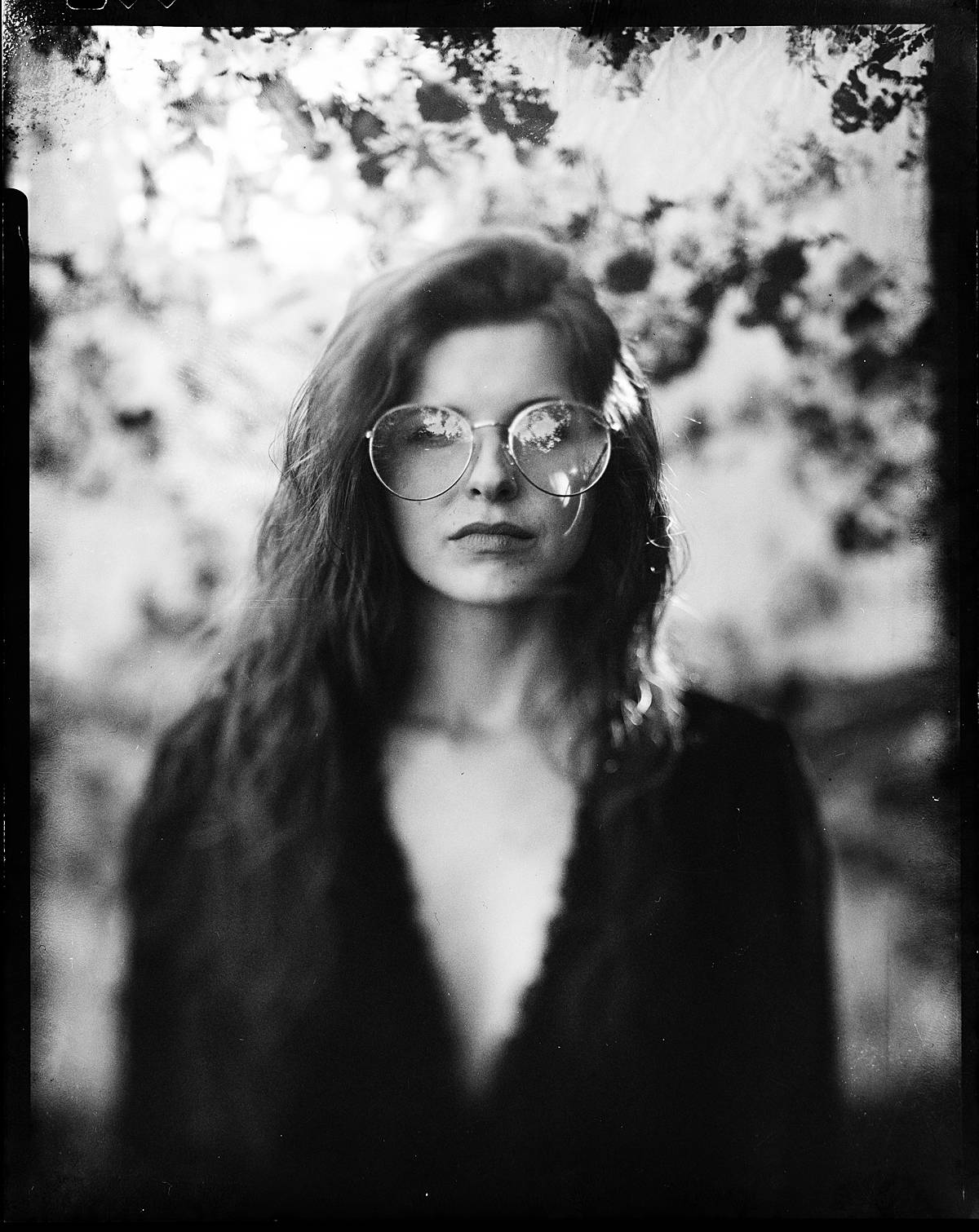 4x5 large format film portrait on black and white expired kodak t-max 400 film of a girl in black dress and sunglasses