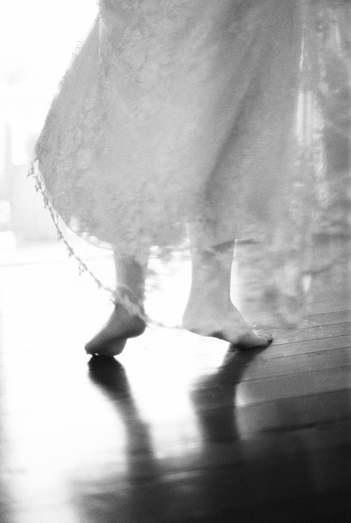charleston bride in boudoir robe running up stairs at 86 cannon wedding venue dancing barefoot on black and white film