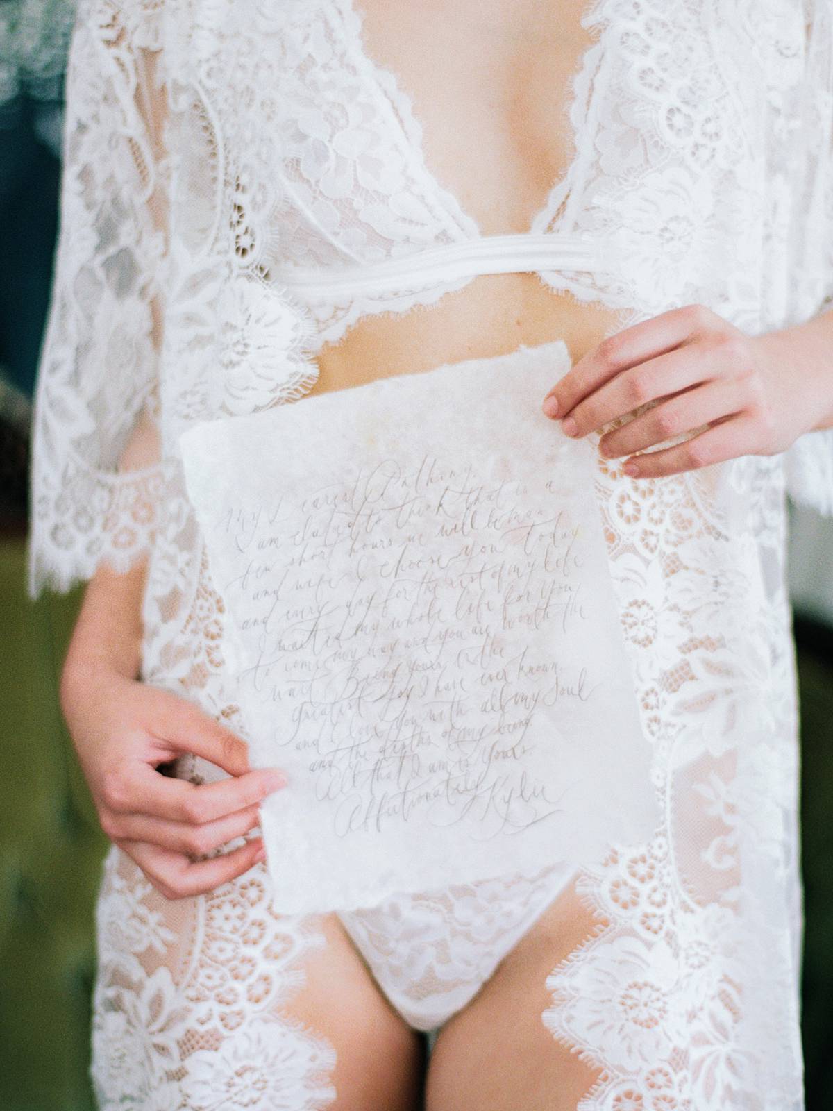 charleston bridal boudoir on film with bride holding hand made letter at wingate plantation in lingerie and lace robe