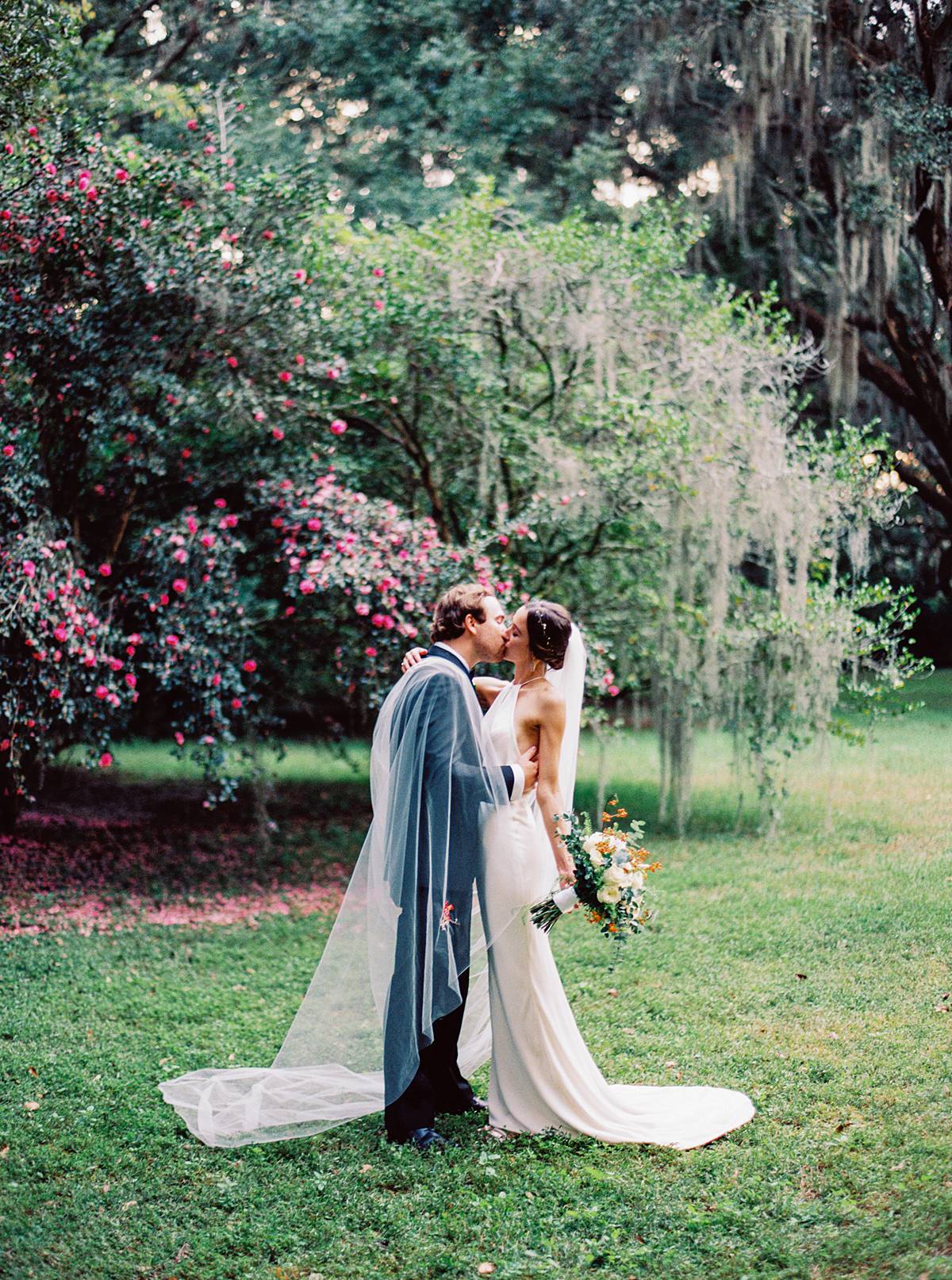 wedding portrait at legare waring house in charleston sc on kodak portra 800 film with blooming flowers on oak trees