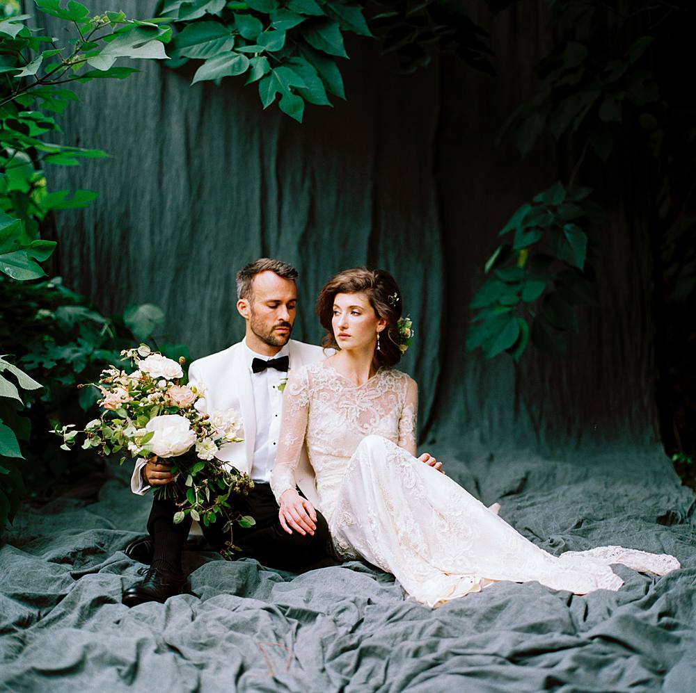 hasselblad and kodak film portrait of a charleston bride and groom in lace cream dress and white dinner jacket tuxedo in outdoor wedding portrait studio