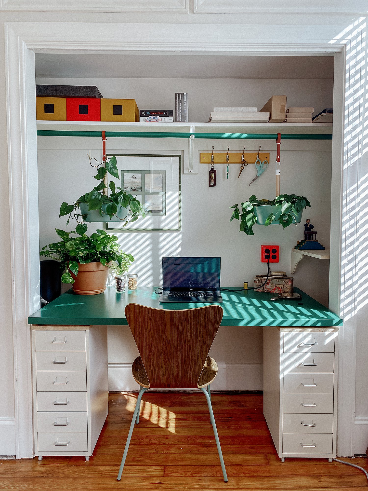 hanging plants in a primary color mid century styled eclectic desk space built into my home photography studio closet