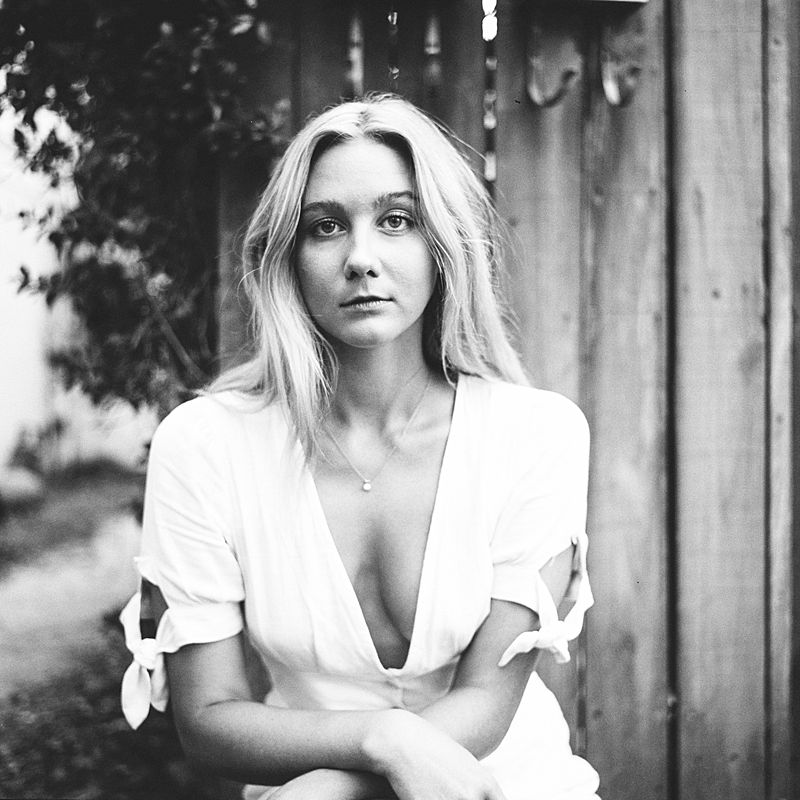 outdoor medium format kodak tri-x 400 film portrait of a girl in white lowcut dress in charleston sc by brian d smith photography