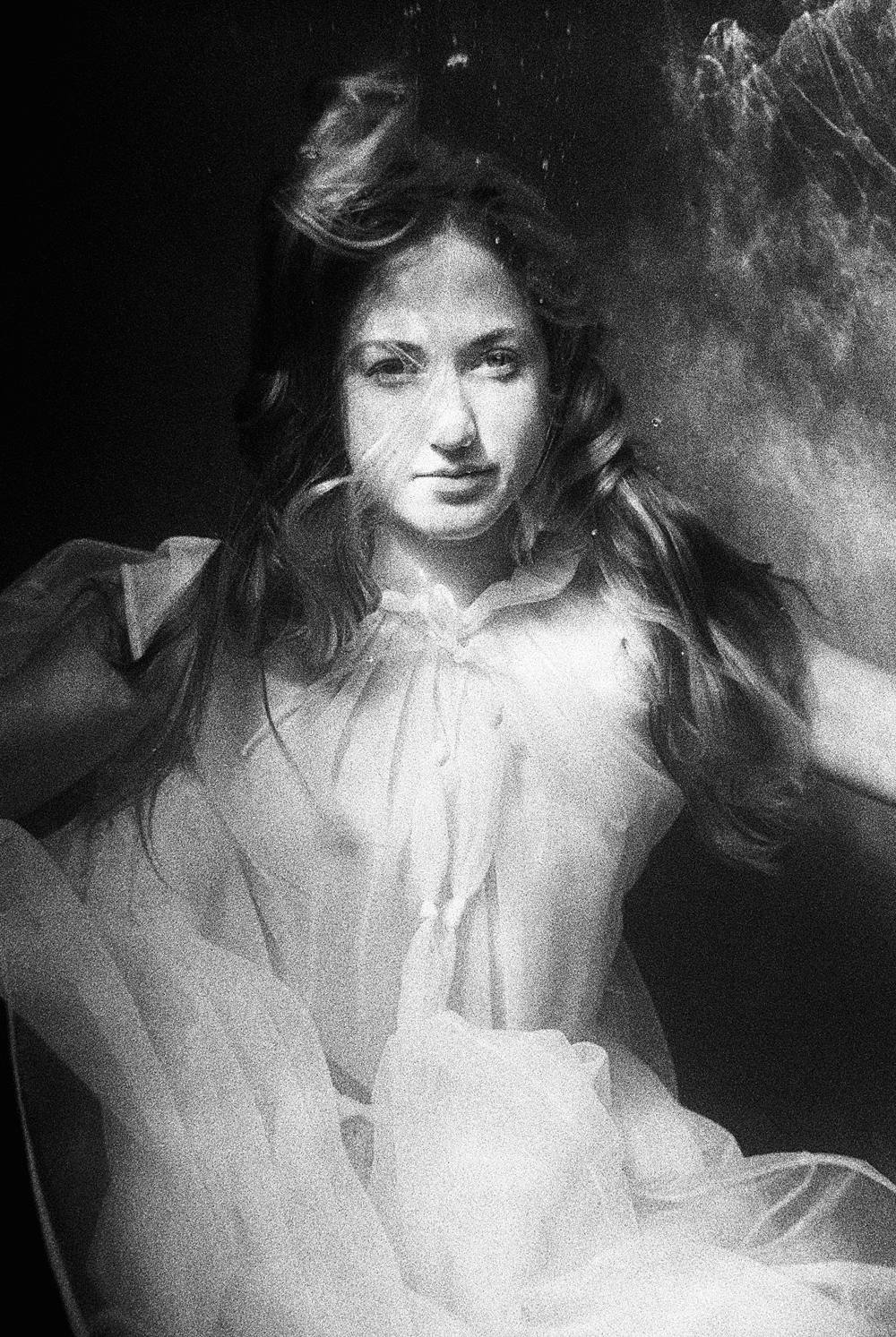 Nikonos v underwater portrait on kodak p3200 film with girl in sheer dress black and white staring at camera