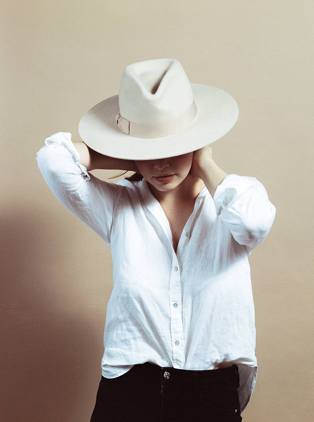 kodak film portrait of girl in studio with mocha savage seamless paper wearing tan felt hat and black jeans