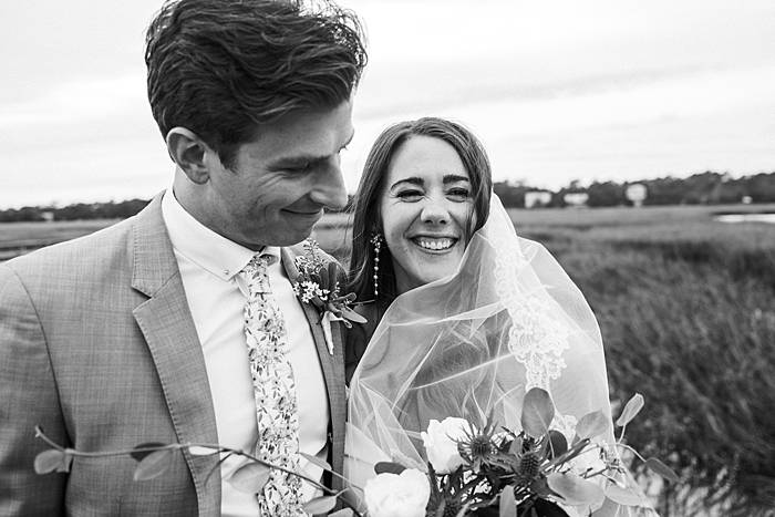 pawley's island pelican inn wedding couple smiling for a candid wedding photograph in black and white