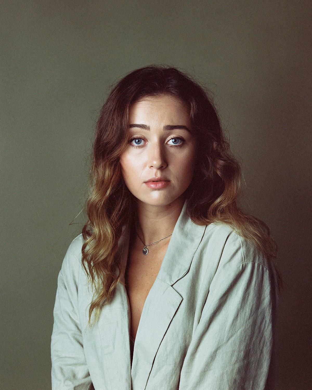 kodak portra 160vc expired film portrait of a girl in earth toned blouse against olive savage seamless paper backdrop