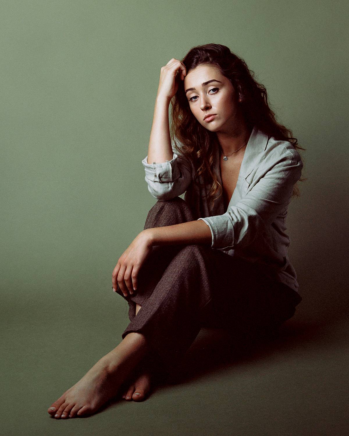 charleston sc photography studio film portrait of girl in earth toned clothes against olive savage seamless backdrop