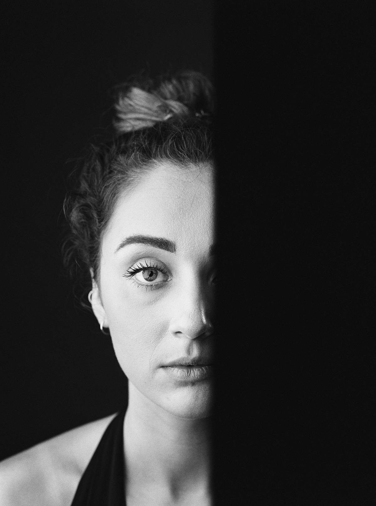 studio portrait of girl on film with strobes in front of black seamless paper with shutter curtain cut off