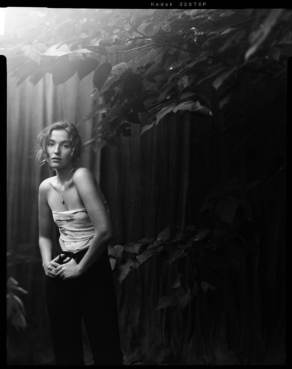 large format film fashion portrait of girl in black jeans and bandana top in charleston sc portrait studio