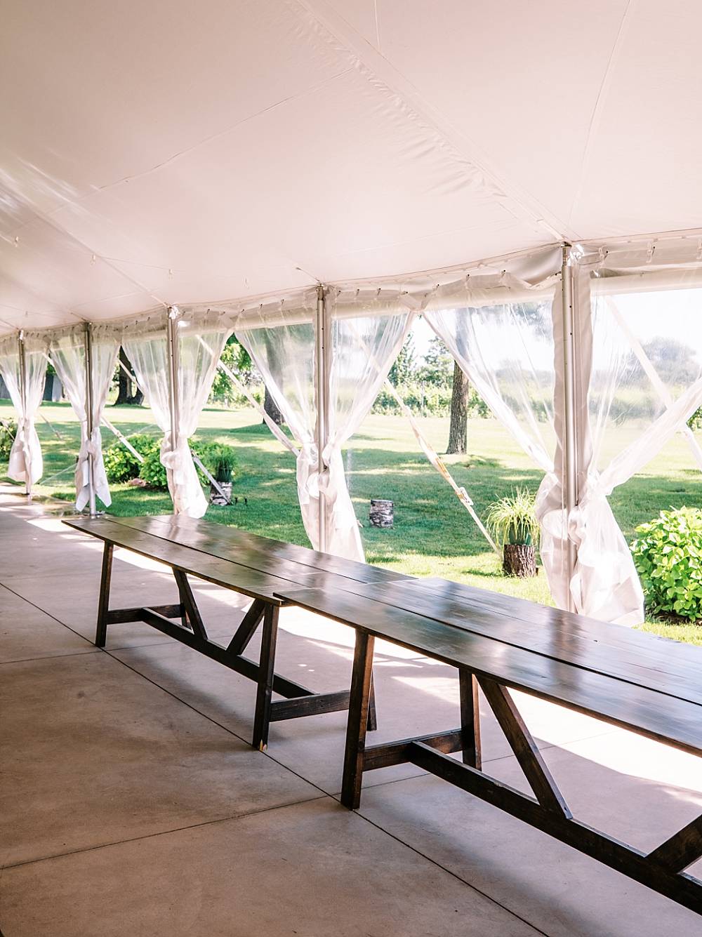 farmhouse tables for wedding reception under tent in northern michigan