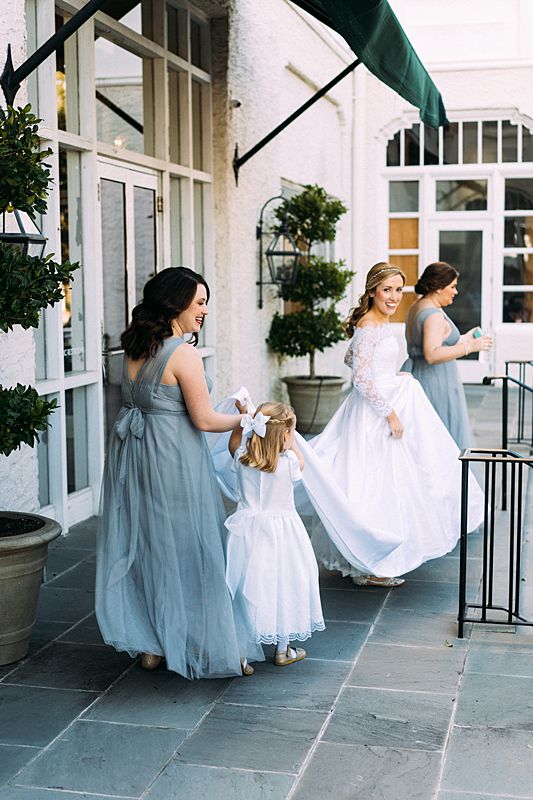 charleston bride at the battery park downtown charleston sc for william aiken house february wedding with bridesmaids in dusty blue dresses