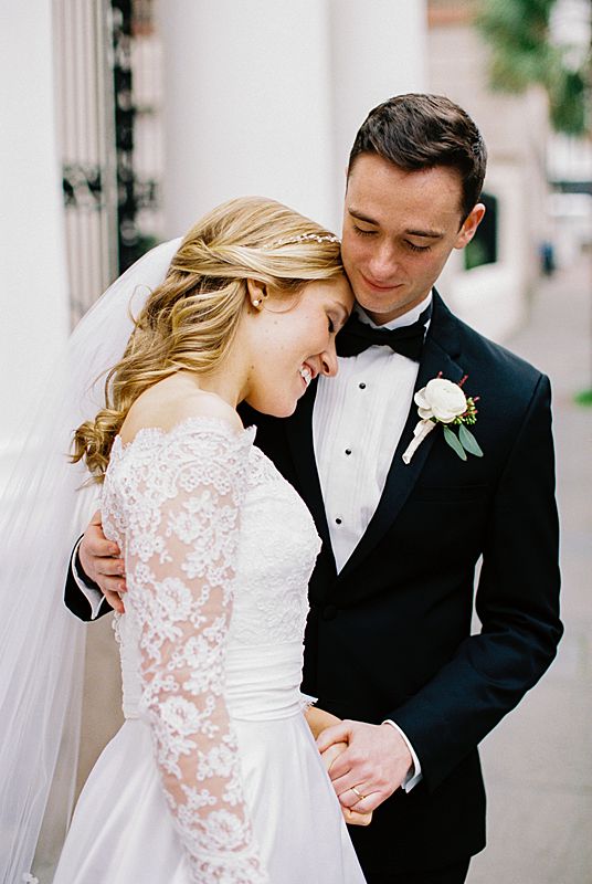 downtown charleston wedding portrait on 35mm film with groom in black tie and bride in white dress before william aiken house reception