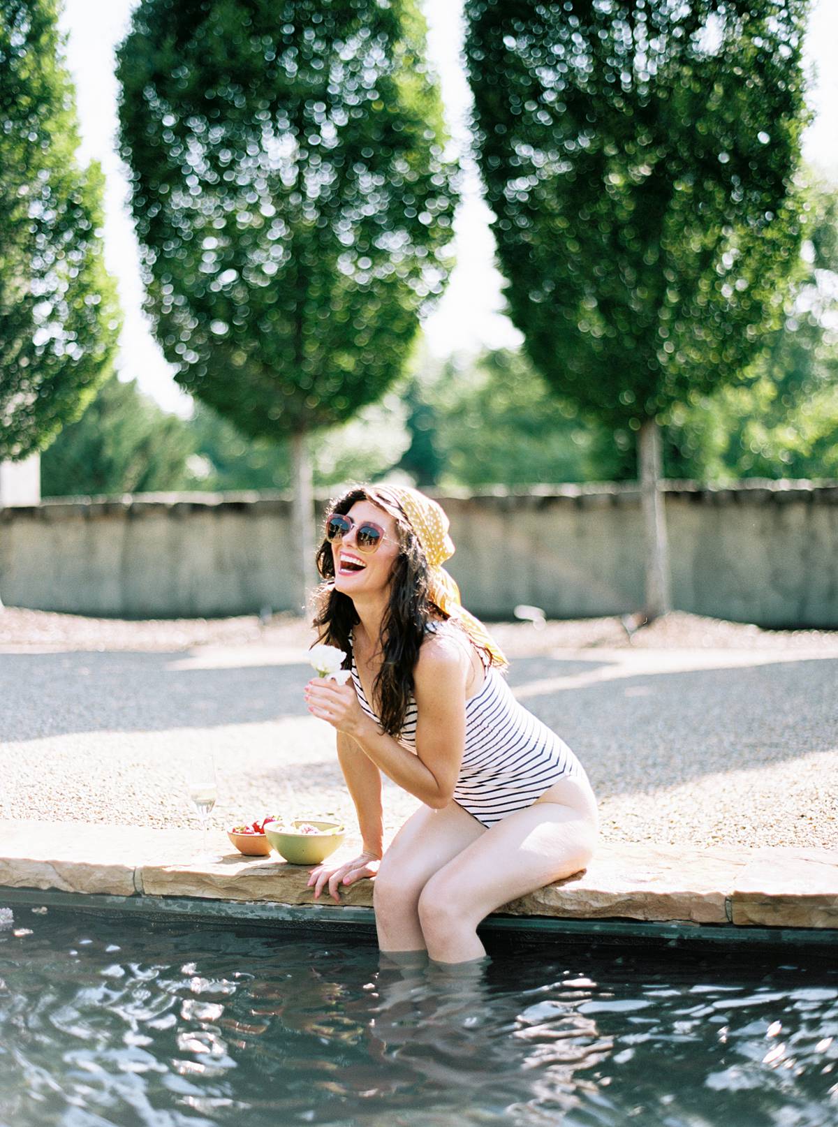 bride picks flowers by pool during weekend micro wedding getaway elopement at hotel domestique near asheville NC