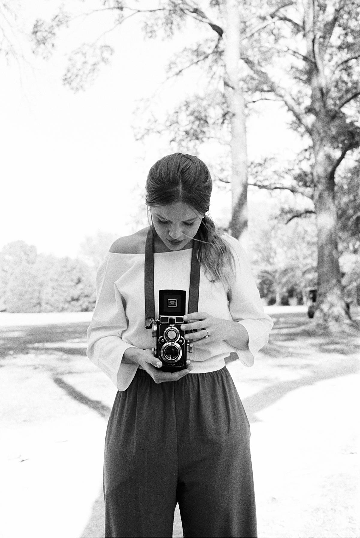 bride photographs groom on vintage film camera during south carolina wavering place micro wedding