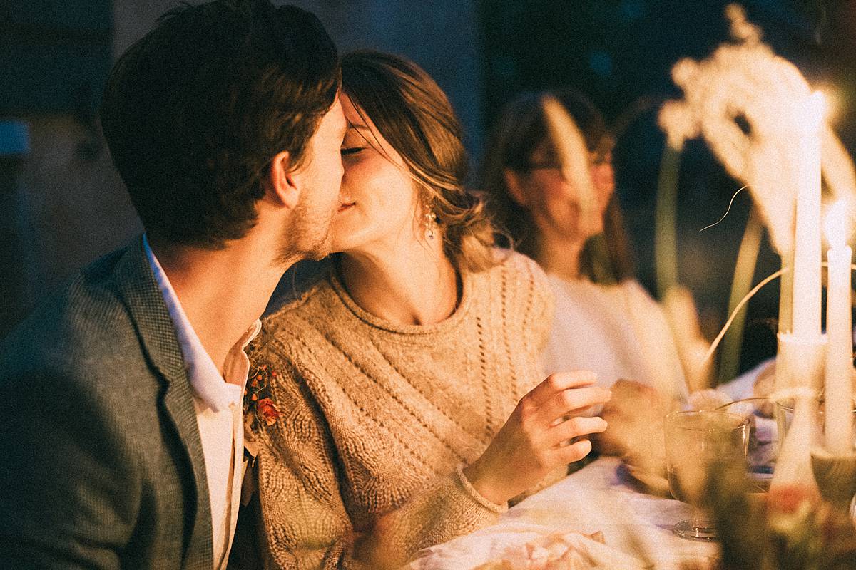 bride and groom kissing at al fresco dinner tablescape during south carolina micro wedding at wavering place