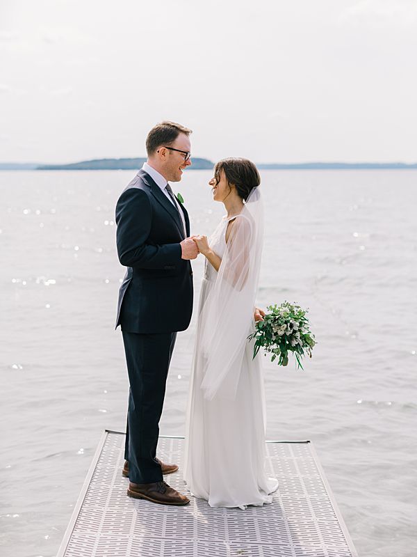 northern michigan wedding couple photographed by the water in traverse city peninsula during august wedding portraits