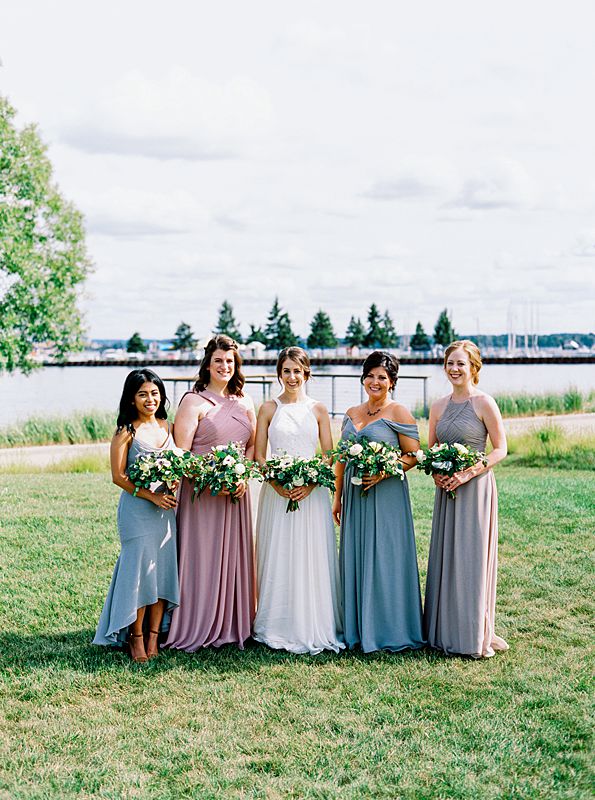 bridesmaids dresses in dusty blue and purple in traverse city michigan with traverse bay behind them on kodak portra 800 film