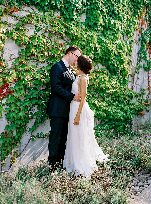 bride and groom against ivy wall at brengman brothers winery during august northern michigan wedding captured on kodak portra 800 film