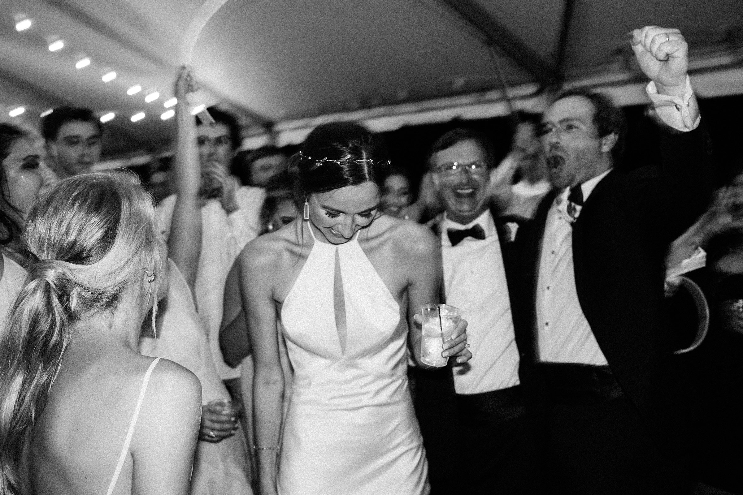 bride laughing during wedding reception in black and white photograph at legare waring charleston sc venue