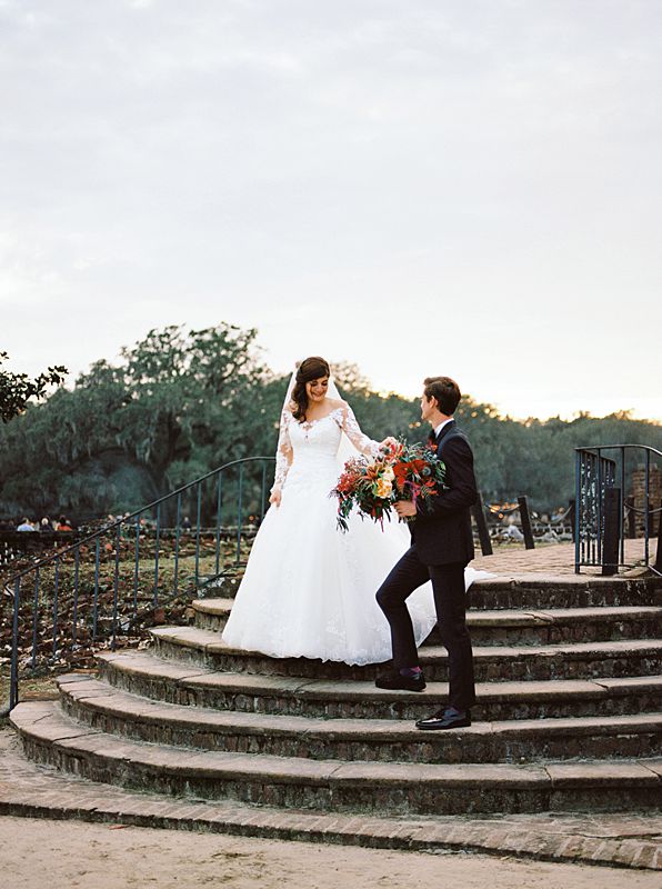 bride and groom descending stairs at middleton plantation during their wedding portraits for their charleston sc wedding captured by brian d smith photography on film