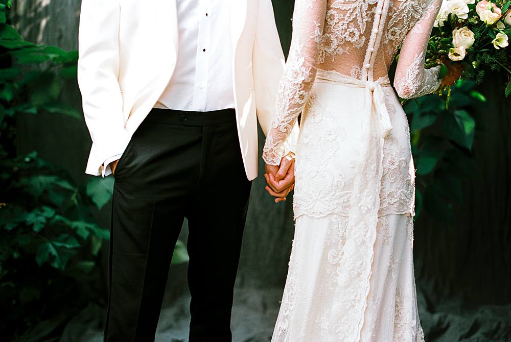 black tie wedding bride and groom film portrait with cream lace claire pettibone gown and white dinner jacket in charleston sc portrait studio